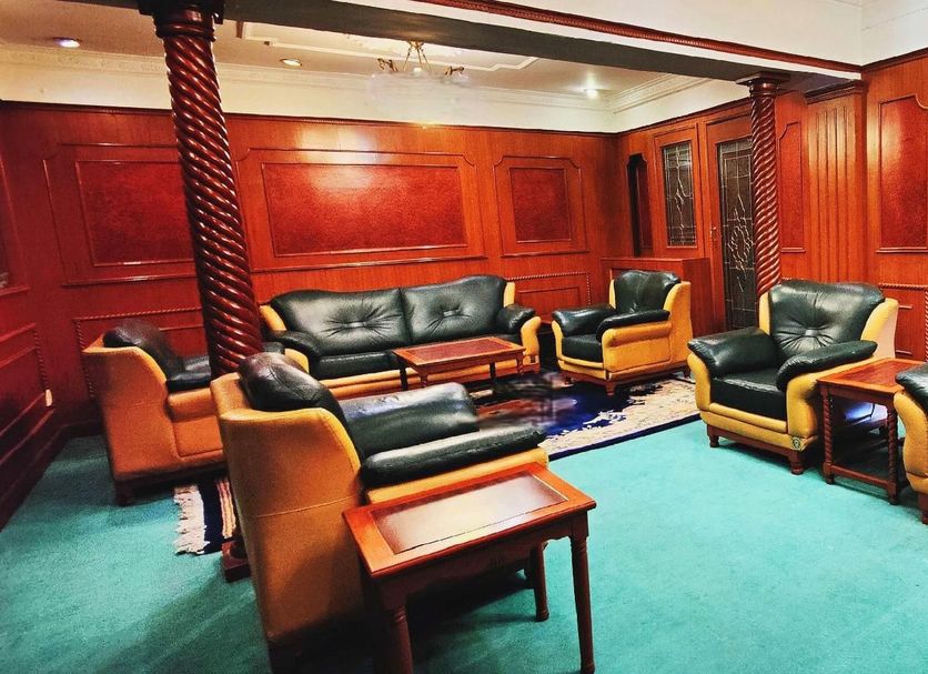 Jinshan Hotel Shanghai lounge with green carpet, leather sofas, and wood-paneled walls