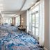 Crowne Plaza Ft. Myers Gulf Coast lobby corridor in Fort Myers with blue patterned carpet and large windows