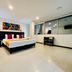 Hotel Ferias Park Bogotá guest room with king bed, desk and large interior windows