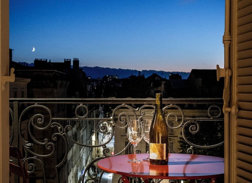 Hotel Amista Marseille balcony with wine on table and city skyline at dusk in Marseille