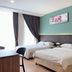 Tumike Hotel Bentong guest room with two beds, window curtains, and floral wall art in Bentong