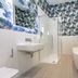 The Lane Hotel Edinburgh bathroom with freestanding tub, walk-in shower, sink and patterned wallpaper