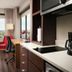 Canal Street hotel room in New Orleans with city view, desk, chair, and compact kitchenette
