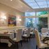 Les Thermes de l'Avenue, Dax dining room with set tables, white chairs and large garden-facing windows