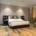 Jinan Jier Hotel guest room in Jinan with king bed, armchairs, and patterned carpet