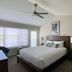 Tilghman Island Inn guest room with king bed, ceiling fan, window blinds and water view