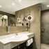 Parkhotel Cup Vitalis bathroom in Bad Kissingen with double sink, large mirror, and walk-in shower