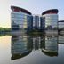 Wuxi Idea Garden Hotel in Wuxi beside a calm lake, with curved towers reflected in the water