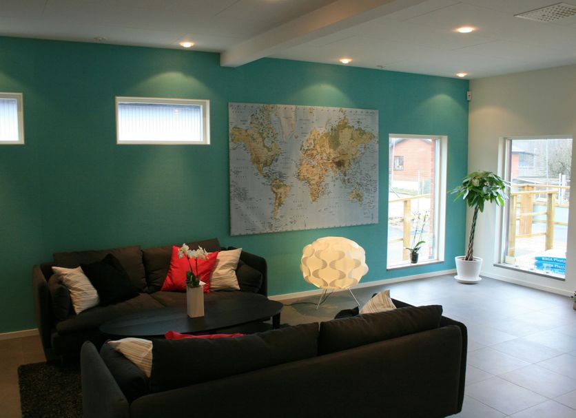 Flygplatshotellet in Härryda lounge with teal walls, black sofas, world map and tall windows