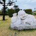 The Nagoya Plasa Redpartner in Batam: stone laughing Buddha statue on a lawn with trimmed hedges