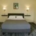 The Marquette Hotel in Madison guest room with a bed, wall sconces, and framed artwork