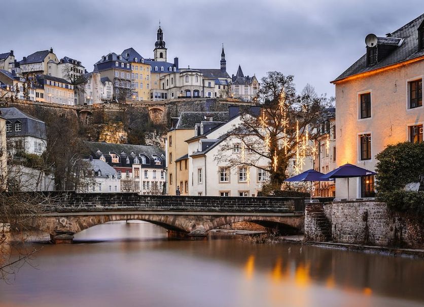 Legere Hotel Luxembourg in Luxembourg with a riverside bridge and hillside historic skyline at dusk