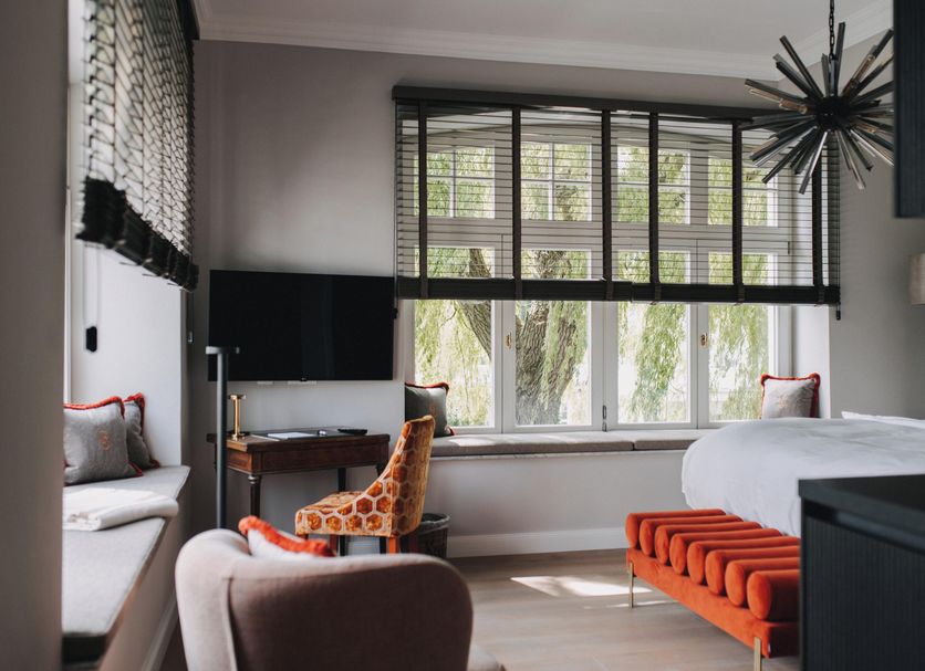 The Reset, Waren: modern hotel room with large window, desk, bed and orange bench