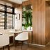 Hotel Eiffel Turenne in Paris breakfast area with wood paneling, white chairs, and large window blinds