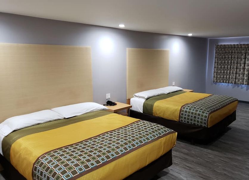 Regal Inn Los Angeles room with two double beds, gray walls, and carpeted floor