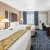 Baymont by Wyndham Port Arthur/Groves Area guest room with two beds, TV, desk and window