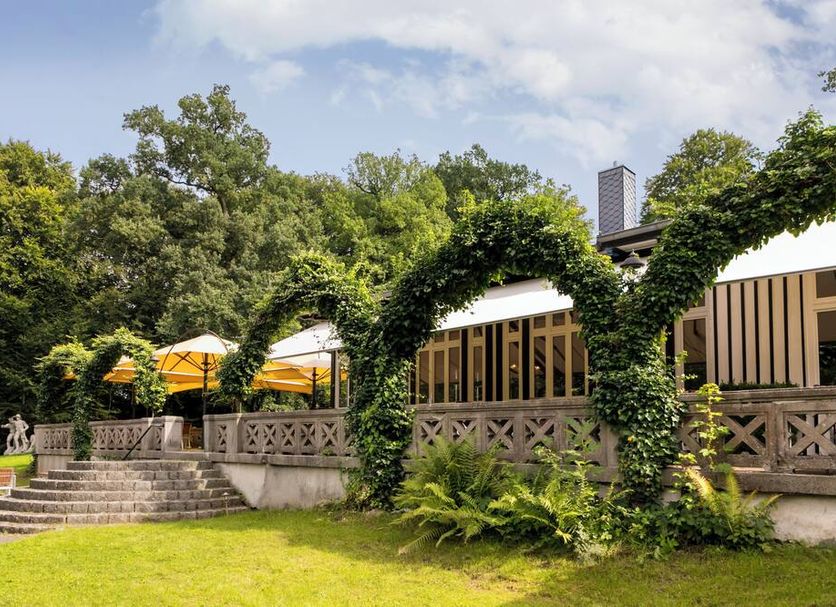 Hotel Waldesruh Am See in Aumühle with ivy-covered arches, terrace, and garden seating