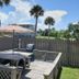 Studio 1 Motel in Daytona Beach with a fenced outdoor deck, picnic table, grill, and palm trees