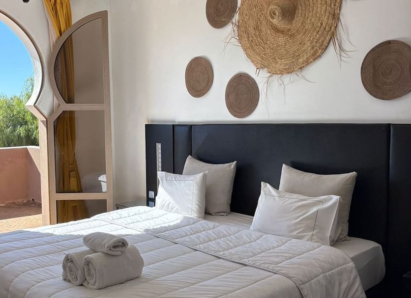 Domaine du Douar Marrakech bedroom with open doorway to terrace and arched view, twin beds