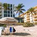 Hillsboro Beach Resort By Kasa, Hillsboro Beach beachfront with chairs, umbrella, palm trees and hotel tower