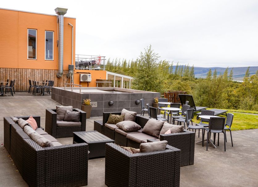 Hotel Hallormsstadur outdoor patio with lounge seating, dining tables, and forest and water views in Egilsstaðir