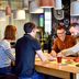 Guests chatting at the bar in Novotel Bordeaux Lac, Bordeaux, with hanging pendant lights