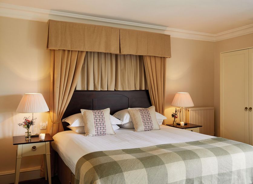 Macdonald Botley Park Hotel & Spa Southampton bedroom with king bed, bedside lamps and wardrobe