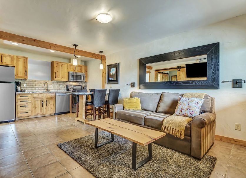 Wall Street Suites Bend living room with sofa, coffee table, dining area and kitchen