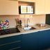Apartments Antonio in Cavtat kitchen with blue cabinets, stovetop, sink, and microwave