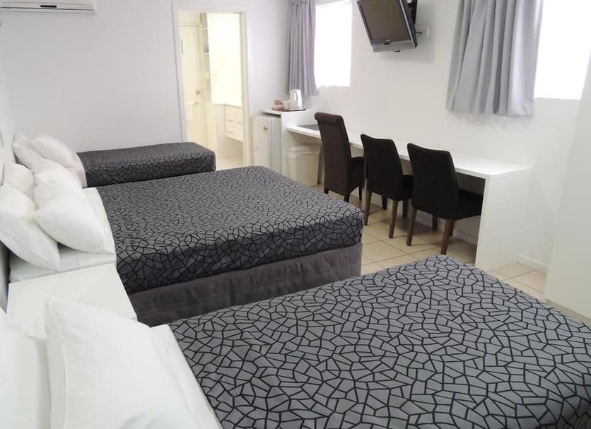 Park View Motel Gladstone room with three beds, desk, chairs and wall-mounted TV