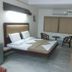 Hotel Rajmata Pvt Ltd, Hyderabad guest room with bed, window, chairs and TV