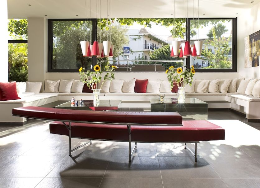 Almyrida Resort in Almyrida lobby lounge with white sectional seating and red accents