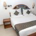Hotel Maurya International in Chennai, a neatly made double bed with bedside lamps and a small table