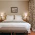 Château de Fonscolombe in Le Puy-Sainte-Réparade, elegant bedroom with a king bed and bedside lamps