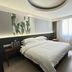 Hangzhou Sailing International Hotel room with king bed, tropical wall art and bright window in Hangzhou