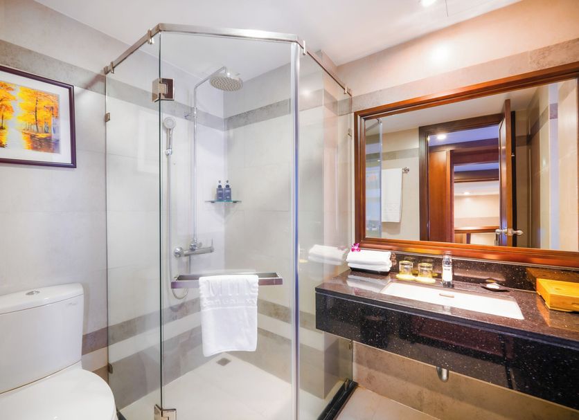Minh Toan Galaxy Hotel Da Nang bathroom with glass shower, toilet and vanity sink