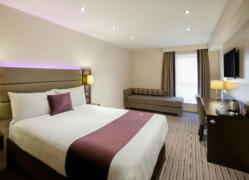 Premier Inn Aberdeen City Centre guest room with king bed, sofa, desk and wall-mounted TV in Aberdeen