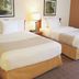 La Quinta Inn & Suites by Wyndham Sawgrass in Sunrise guest room with two double beds and bedside lamp