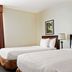 La Quinta Inn & Suites by Wyndham Sawgrass in Sunrise: guest room with two double beds and framed wall art