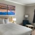 Days Inn by Wyndham Rockdale Texas guest room with king bed, bedside lamps and abstract wall art
