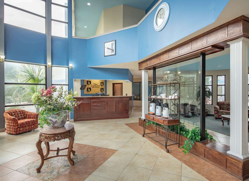 Baymont by Wyndham Laurel lobby with front desk, tall windows, and glass display case