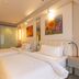 Jinjiang Metropolo Hotel Shenyang room with two twin beds, wall art, and frosted glass partition
