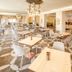 Le Bristol Leukerbad dining room in Leukerbad with bright seating, patterned carpet, and chandeliers