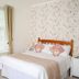 The Parks Guest House in Minehead bedroom with double bed, patterned pillows and window with curtains