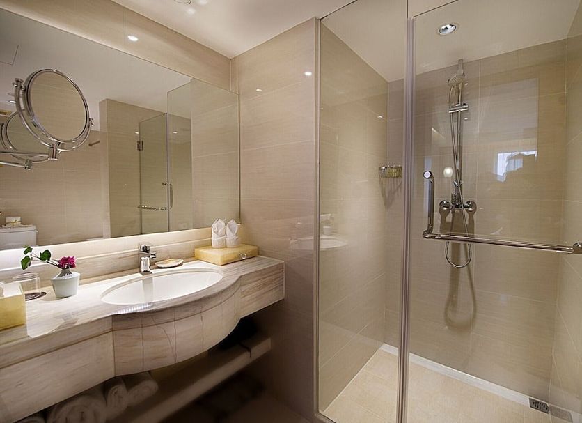 Grand Metropark Hotel Hangzhou bathroom with vanity sink, mirror, and glass shower in Hangzhou