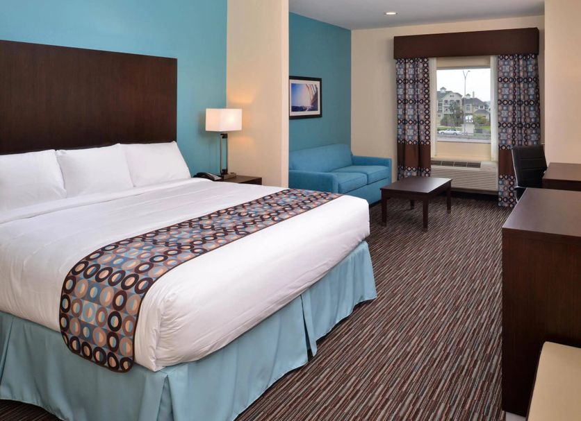 Holiday Inn Galveston Island guest room with king bed, sofa, desk and window view
