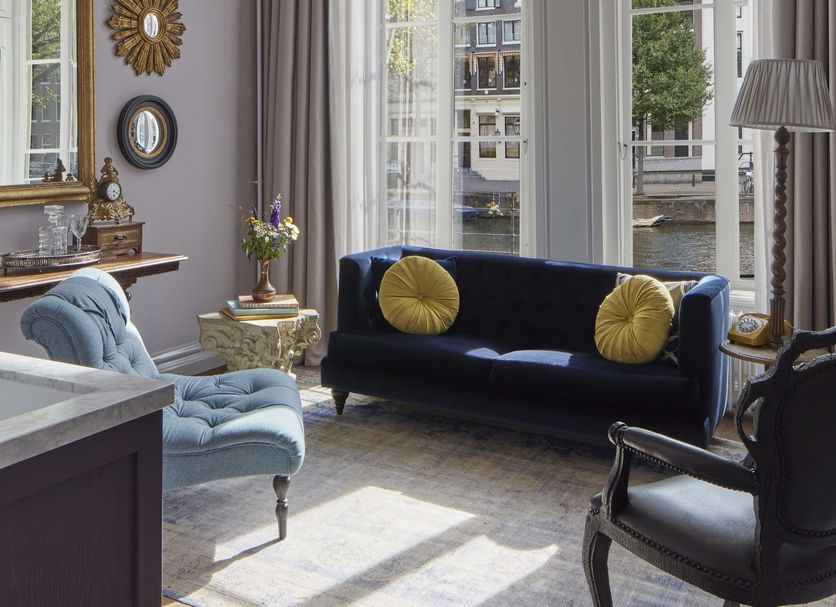 Pulitzer Amsterdam lounge with chandelier, tall windows, and canal-side city view