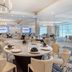 Cambria Hotel Waco University Riverfront dining room with set tables and chandeliers in Waco