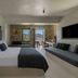 Rocabella Mykonos Hotel in Agios Stefanos guest room with king bed, sofa, and sea view terrace