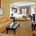 Holiday Inn Express & Suites Durant By IHG guest room with king bed, sofa, desk, and kitchenette